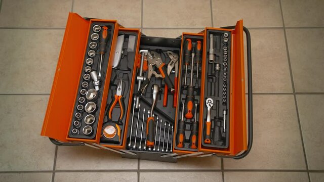 Hands takes the wrench from the toolbox