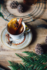 whiskey hot toddy cinnamon orange star anise in vintage teacup on wood bourbon barrel holiday happy...