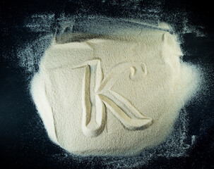 Greek letter kappa written on the white sand with black background