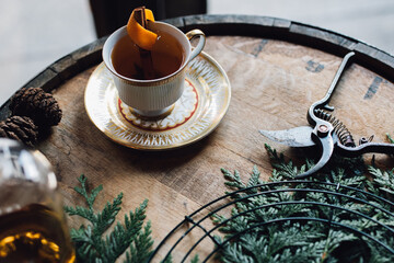 whiskey hot toddy cinnamon orange star anise in vintage teacup on wood bourbon barrel holiday happy...