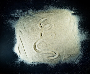 Greek letter xi written on the white sand with black background