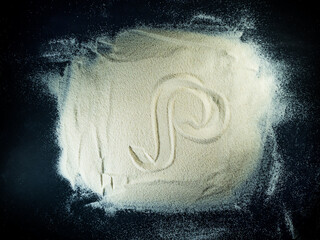 Greek letter rho written on the white sand with black background