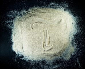 Greek letter tau written on the white sand with black background