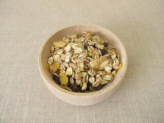 Fruit muesli with whole grain flakes and dried fruits in a wooden bowl