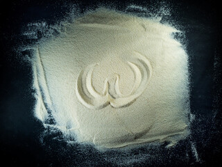 Greek letter omega written on the white sand with black background