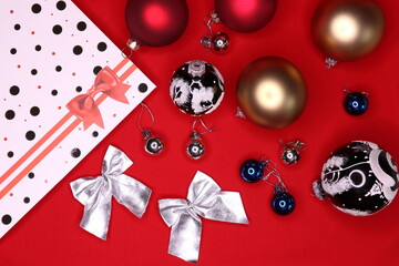 Top view of christmas tree decorations and gift bag on red background