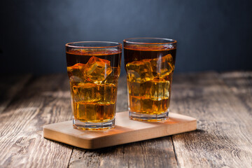 Alcoholic cocktail with ice in a large faceted glass, close-up