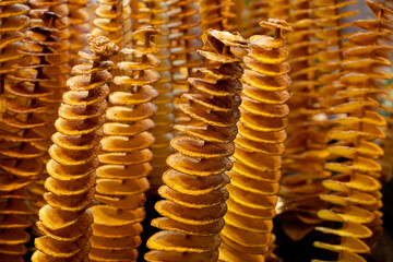 Twisted fried potato chips in a stick at the market. Unhealthy street food