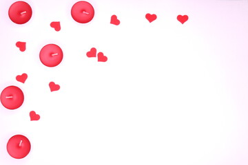 Top view on red candles and small hearts on white background 