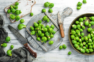 Vegetables. Fresh green brussels sprouts on a white wooden background. Rustic style. Top view.