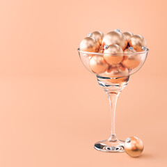 Christmas  festive composition. A glass of champagne filled with Christmas balls in a warm...