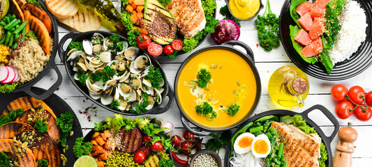 Food banner: pasta, chicken, pumpkin, salad, meat, mushrooms. On a white wooden background. Top view. Free space for text.