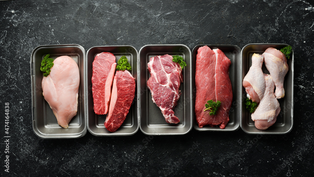 Wall mural set of fresh raw meat: veal, chicken, pork. on a black stone background. organic food.