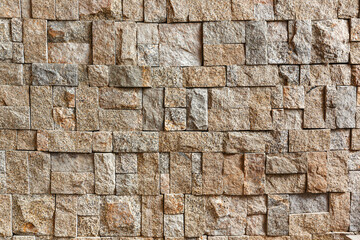 The rough texture of the surface of the wall faced with rectangular granite blocks of different sizes.