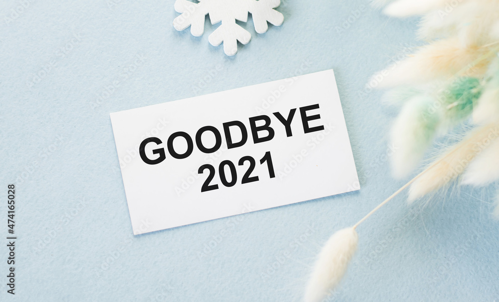 Poster text bye bye 2021 text on a card on a row of snowflakes and dried flower branches