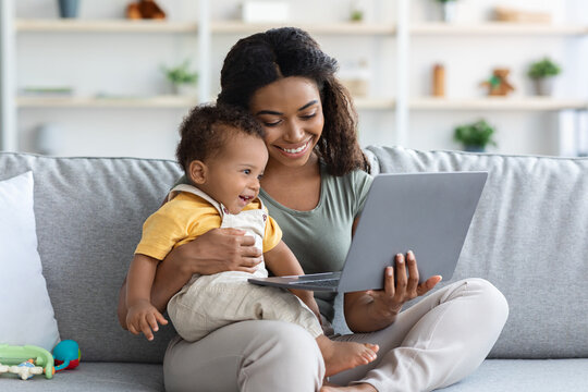Happy African American Mother And Infant Baby Using Laptop At Home
