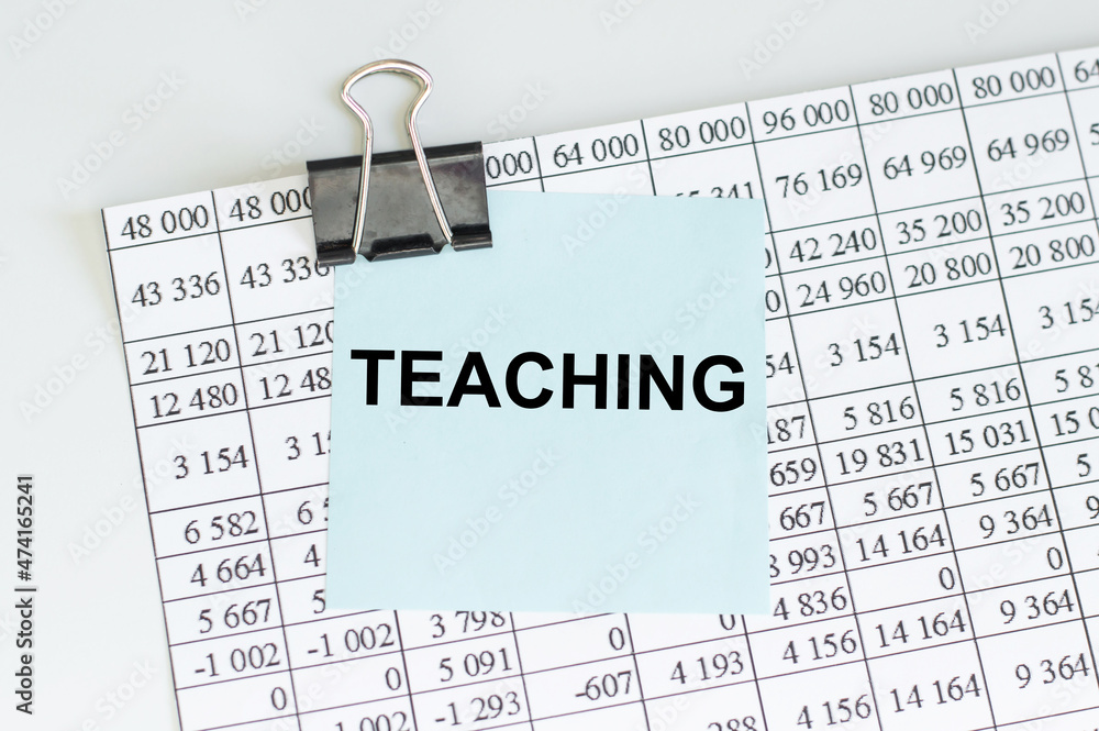 Poster the text teaching on the table next to the sheet with numbers and the clip with the card with the te