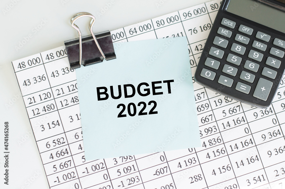Poster text budget 2022 on a card clip to a report sheet on the table next to the calculator