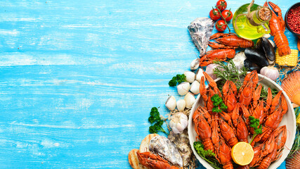 boiled crawfishes on table in rustic style, on a blue wooden background. Top view. Flat lay.