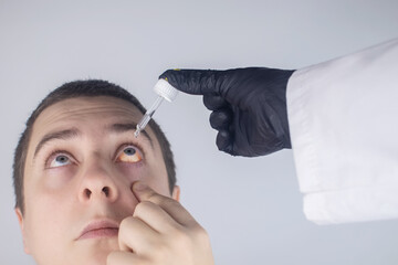 Close-up of eye drops. A man at the doctor appointment, who drips drops into the patient eyes....