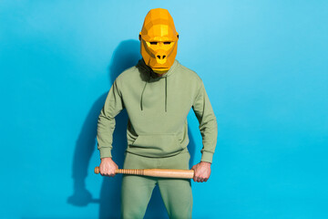 Photo of careful sporty guy hold bat warning position wear gorilla mask isolated blue color...