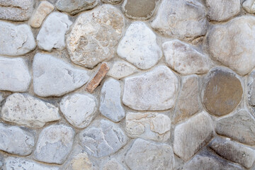 Neatly stacked rough cut stone wall seamless texture background.
