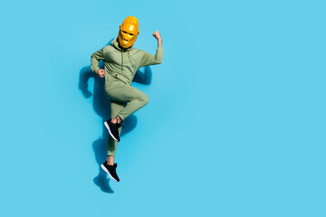 Fototapeta na wymiar Photo of nice cheerful guy jump have fun wear polygonal chimpanzee mask sportswear isolated blue color background