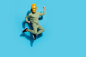 Obraz na płótnie Canvas Photo of triumphant guy jump raise fists wear polygonal gorilla mask sportswear isolated blue color background