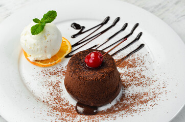 Dessert. Traditional chocolate fondant with ice cream and chocolate on a plate. Top view.