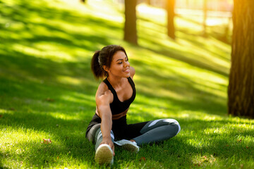 Healthy african woman warming up before jogging by park