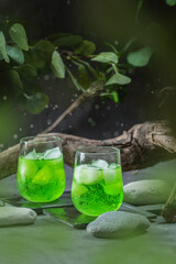 Green fresh summer lemonade with lemon on dark background