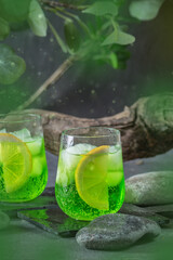 Green fresh summer lemonade with lemon on dark background