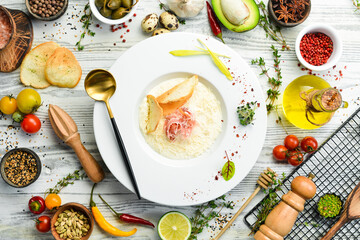 Cheese cream soup with prosciutto. Italian cuisine. Top view. Rustic style.