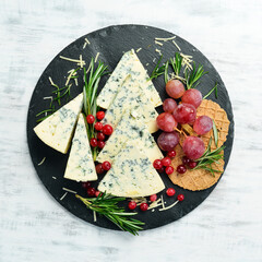 Blue cheese with mold on a plate with snacks. Rustic style. Free copy space.