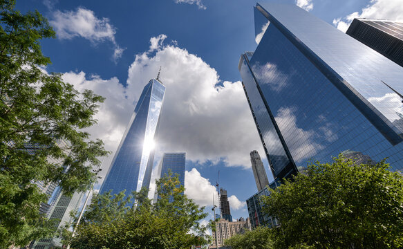 One World Trade Center skyscraper office building in Manhattan, New York, in a sunny day with blue sky and amazing reflections. One of the best sights and landmarks in America. - Powered by Adobe