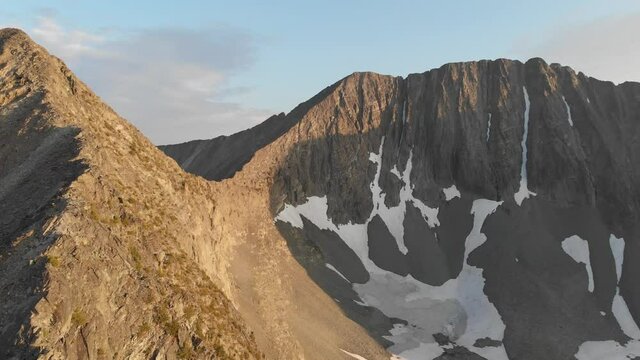 Flying over rocky ridge line at sunset 