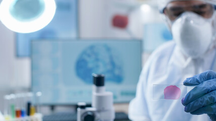 Closeup of scientist researcher doctor holding medical slide analyzing blood sample working at coronavirus vaccine during chemistry experiment in biochemistry hospital laboratory, Virus examination