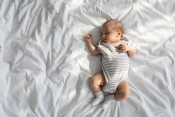 Top View Shot Of Adorable Little Newborn Baby Sleeping In Bed