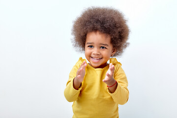 Excited black fluffy child girl clapping and applauding, happy and joyful, smiling. Adorable...