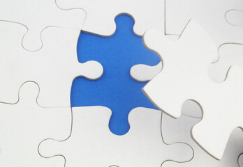 White jigsaw puzzles background, one piece missing and ready to connecting. Business strategy,  teamwork, problem solving and complete mission concept. 