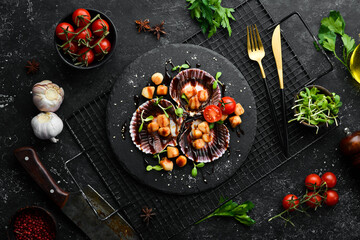 Baked scallops in shells with vegetables on a black stone plate. Luxury restaurant food. Seafood. Rustic style. Flat Lay.