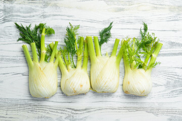 Organic fennel on a white wooden background. Healthy food. Top view. Free space for your text. - obrazy, fototapety, plakaty