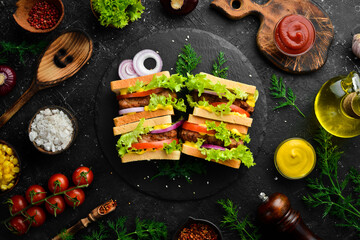 Sandwich with cutlet, cheese and lettuce on a black stone background. Street food. Top view. Free copy space.
