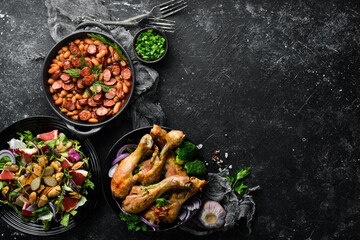 Set of dishes of meat and vegetables on black background. Top view. Free space for your text.