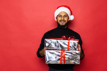 Santa christmas man in red with background holding and opening golden gift present