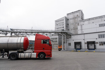 Red tanker truck goes on the territory of the plant of sunflower oil production