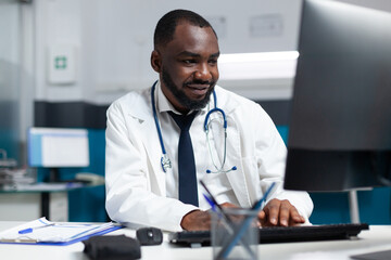 African american therapist doctor in uniform analyzing sickness expertise on computer typing online...