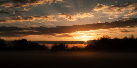 Fototapeta na wymiar Beautiful sunrise with cloudscape sunbeams and fog