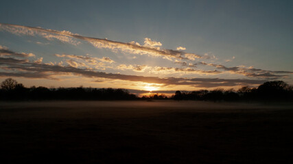 Beautiful sunrise with cloudscape sunbeams and fog