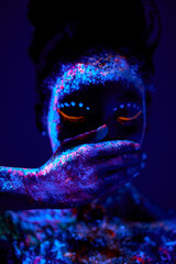Abstract shoot of beautiful black female closing mouth with hands, with fluorescent body art. calm peaceful lady keep silence, close-up portrait. art, fashion concept. body-paint, isolated